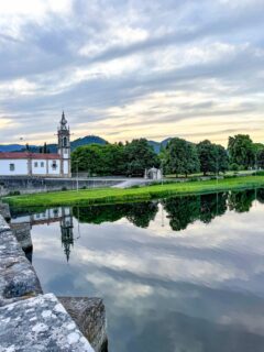 Ponte de Lima tiene algo difícil de explicar. 
Quizá sea el puente romano y medieval, sus terrazas tranquilas o ese ritmo pausado que hace que quieras quedarte más tiempo del previsto. 
 
Dicen que los romanos se negaban a cruzar el río Lima. Creían que era el Leteo, el río del olvido. 
Tuvo que ser un general quien, desde la otra orilla, empezó a llamar a cada soldado por su nombre para demostrar que no lo olvidarían. 
 
Si vais, yo recomiendo cruzar el puente al atardecer, perderos por el casco histórico y visitar el Centro de Interpretación del Vinho Verde @cipvv, donde se entiende mucho mejor la relación de esta zona con el vino. 
 
También merece la pena subir a la Torre da Cadeia Velha, uno de los restos medievales más reconocibles de la ciudad, recorrer la Ecovia do Rio Lima caminando junto al río y acercarse al Parque Temático do Arnado, un jardín muy cuidado con diferentes espacios inspirados en estilos históricos. 
 
Y si os coincide ir hasta el mercadillo que hacen junto al río, cada segundo domingo de cada mes por la mañana (hasta las 13:00) 
 
Otras cosas que no me perdería: 
 
• Museu dos Terceiros: si os gusta el arte sacro y la historia, está en un antiguo convento y tiene una buena colección de tallas doradas y pintura. 
 
• Centro de Interpretação da História Militar: ubicado en el Paço do Marquês, permite entender la importancia estratégica de Ponte de Lima a lo largo de los siglos. 
 
• Lagoas de Bertiandos: a unos 20 minutos en coche. Naturaleza, pasarelas y muchísima tranquilidad. 
 
• Museu do Brinquedo Português: pequeño y curioso, incluso si vais sin niños. 
 
Y para sitios donde comer… podéis ir dos publicaciones atrás 😉 
 
Uno de los platos más típicos de la zona del Miño es el Arroz de Sarrabulho, elaborado con sangre de cerdo. Lo tradicional es acompañarlo con Rojões à moda do Minho. 
 
Si no os convence el tema de la sangre, muchos restaurantes también ofrecen Arroz de Pica no Chão. 
 
Y no os vayáis sin probar el Leite Creme, una especie de crema catalana al estilo portugués, o el Pudim do Abade de Priscos. 
@turismo_portoenorte