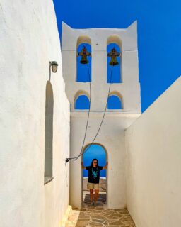 En Sifnos hay 237 iglesias y monasterios. En una isla de 74 km², es la mayor concentración de iglesias de todas las Cícladas.  
No importa hacia dónde mires: en lo alto de una colina, junto al mar o escondida entre los olivos, siempre aparece una cúpula blanca. 
 
Entiendes que las iglesias no son solo parte del paisaje. Son parte de la identidad de Sifnos.

¿Cómo es posible que haya tantas? 
No existe una única explicación. 
 
Durante siglos, los habitantes de Sifnos disfrutaron de una gran libertad para practicar la religión cristiana, algo poco habitual en otras zonas del Egeo durante la dominación otomana. Esa tradición fue creciendo con el tiempo. 
 
Muchas familias, además, dejaban parte de sus propiedades a iglesias y monasterios y asumían el compromiso de mantenerlas y celebrar cada año la festividad de su santo. Así, generación tras generación, fueron construyéndose nuevas capillas que todavía hoy siguen formando parte de la vida de la isla. 
 
Por eso las iglesias de Sifnos no son solo patrimonio histórico. Son el reflejo de una tradición que los propios sifnios han conservado durante siglos.

No todas son parroquias. 
Aunque en Sifnos hay 237 iglesias y monasterios, solo 8 son parroquias. 
 
La mayoría son pequeñas capillas repartidas por toda la isla. Algunas permanecen cerradas gran parte del año y solo abren el día en que se celebra el santo al que están dedicadas o durante festividades muy concretas. 
 
También hay antiguos monasterios que ya no tienen vida monástica, pero siguen siendo lugares de gran valor histórico y forman parte del patrimonio de Sifnos.

Cada iglesia de Sifnos tiene su propia festividad, conocida como panigiri, una de las tradiciones más importantes de la isla. 
 
La víspera del día del santo, vecinos y visitantes se reúnen para compartir una cena preparada en grandes fogones tradicionales. No faltan la revithada, el cordero, el vino local ni la música en directo. 
 
Las mesas se vuelven a llenar una y otra vez hasta que todo el mundo ha comido. Y, en muchos casos, la celebración continúa con canciones y bailes hasta el amanecer.

Cada iglesia ocupa un lugar diferente del paisaje. 
 Algunas se encuentran en el centro de los p